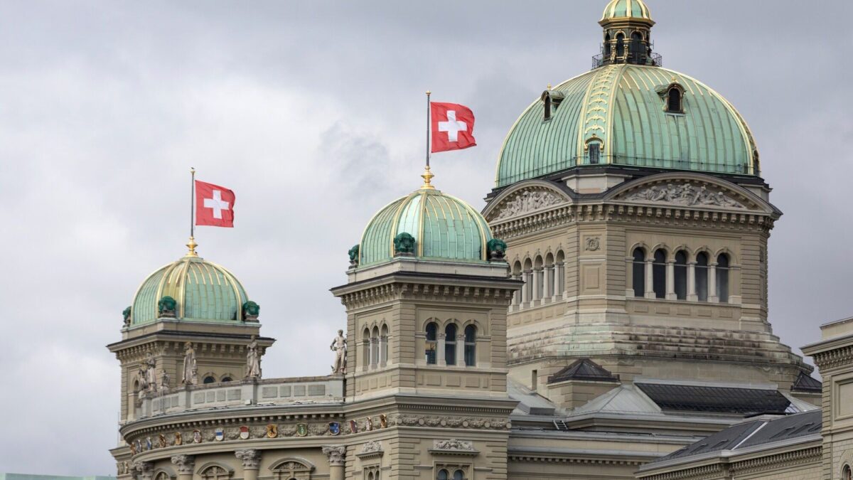 Les coupoles du Palais fédéral à Berne, surmontées de drapeaux suisses